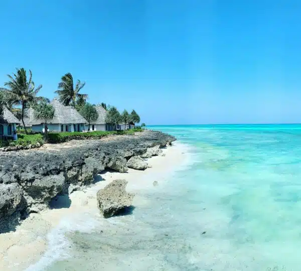rocky beach with white cottages under clear blue sky